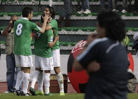 Argentina's coach Diego Maradona stands on the sidelines as Bolivians celebrate their first goal, during their 2010 World Cup qualifying soccer match in La Paz